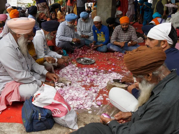 AMRITSAR, INDIA - 2019. március 18.: önkéntesek hagymát aprítanak az aranytemplomban — Stock Fotó