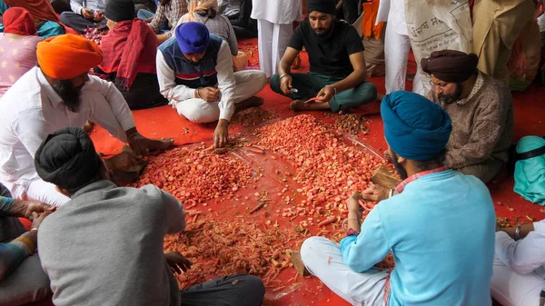 AMRITSAR, INDIA - 18 DE MARZO DE 2019: voluntarios pelando zanahorias en la cocina de templos dorados en Amritsar —  Fotos de Stock