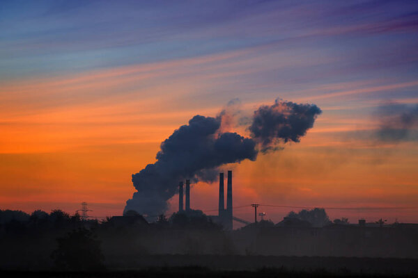 Smoke-screen factory chimneys at sunrise 
