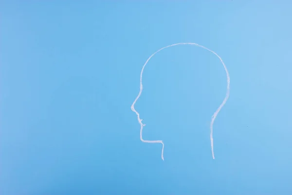 crayon sketched head silhouette on blue background