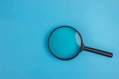Mavi arka plan üzerinde büyüteç. kopya alanı