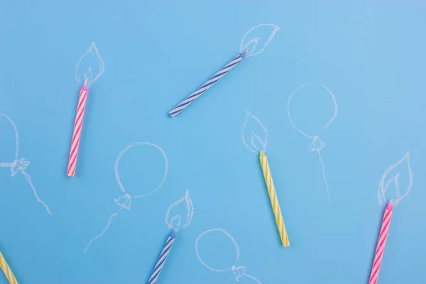 Variety of birthday candles on blue background