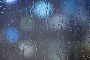 Damla yağmur pencerede, gece. bulanık ışık