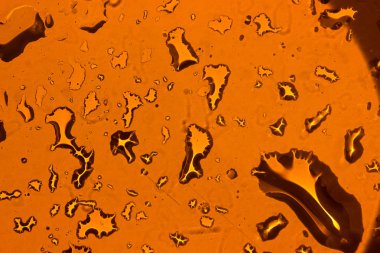 Sarı arka plan üzerinde su damlacıkları. arkadan aydınlatmalı