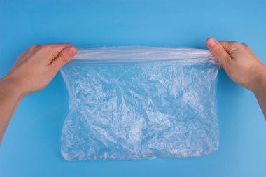 Plastic bag on blue background. pollution concept clipart