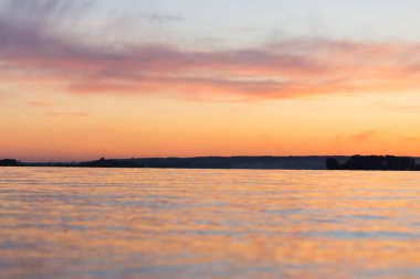 turuncu ve pembe renklerde deniz üzerinde güzel gün batımı