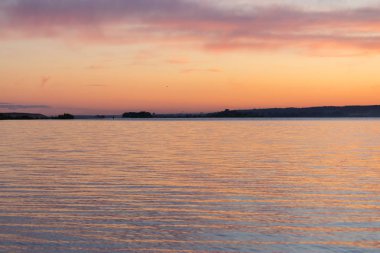 turuncu ve pembe renklerde deniz üzerinde güzel gün batımı