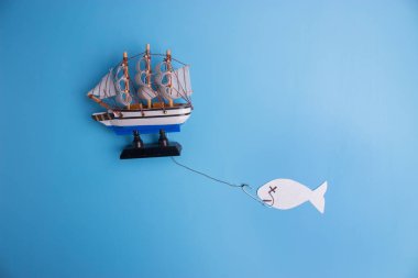 ocean is overfished concept image. paper fish and toy ship clipart