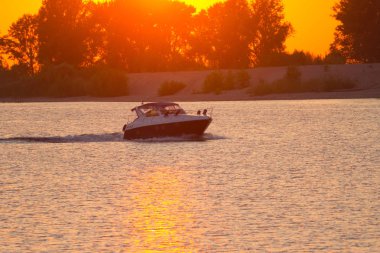 Lüks Nehri üzerinde günbatımında motorlu tekne