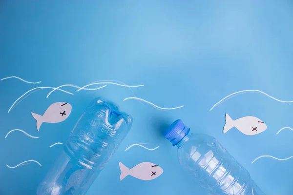 ocean pollution concept image. plastic bottle and paper fish