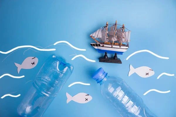 ocean pollution concept image. plastic bottle and paper fish