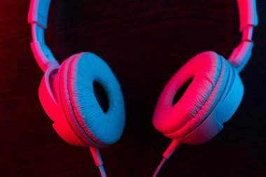 Karanlık arka plandaki kulaklıklar neon ışıklarıyla