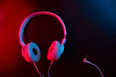 Karanlık arka plandaki kulaklıklar neon ışıklarıyla
