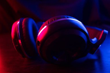 Karanlık arka plandaki kulaklıklar neon ışıklarıyla