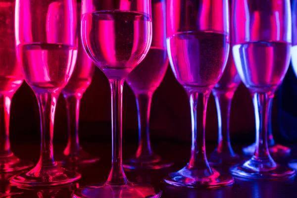 many glasses in neon light. party concept