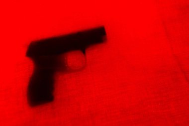 tabanca kırmızı perde arkasında. yakın çekim. yumuşak odak