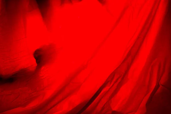 abstract red background. unrecognizable thing behind red curtain