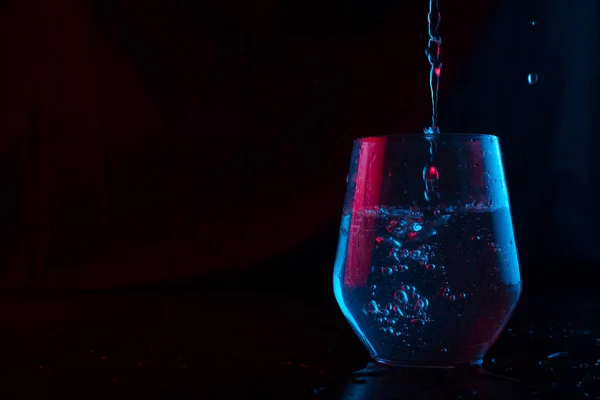 Νερό Τονισμένο Μπλε Και Κόκκινο Πιτσίλισμα Γυάλινο Κύπελλο Μαύρο Φόντο — Φωτογραφία Αρχείου