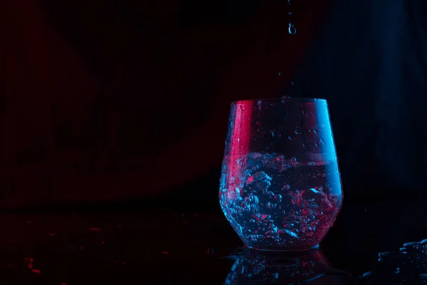 Νερό Τονισμένο Μπλε Και Κόκκινο Πιτσίλισμα Γυάλινο Κύπελλο Μαύρο Φόντο — Φωτογραφία Αρχείου