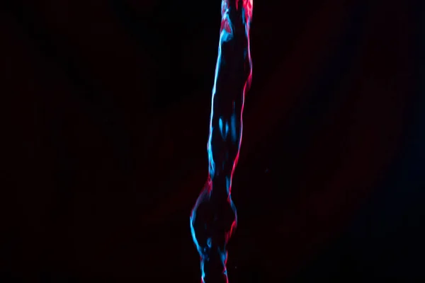 Red and blue neon background from water flow. defocused