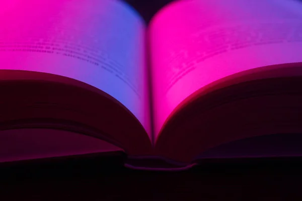 Aufgeschlagenes Buch Mit Rosa Neonlicht Über Dunklem Hintergrund — Stockfoto