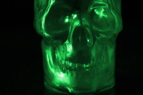 Temeroso destruído crânio humano em luz verde — Fotografia de Stock