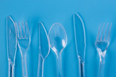 mavi arka plan üzerinde plastik çatal ve bıçaklar