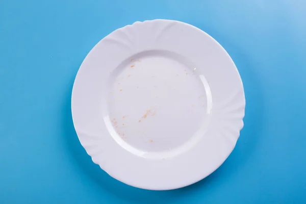 Λευκό πιάτο σε μπλε φόντο — Φωτογραφία Αρχείου