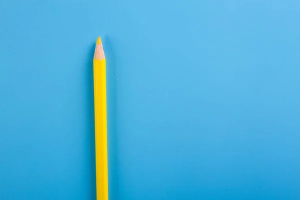 Gelber Bleistift auf blauem Hintergrund — Stockfoto