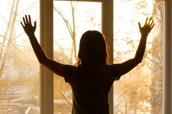 Silhouette of a woman near window Stock Photo