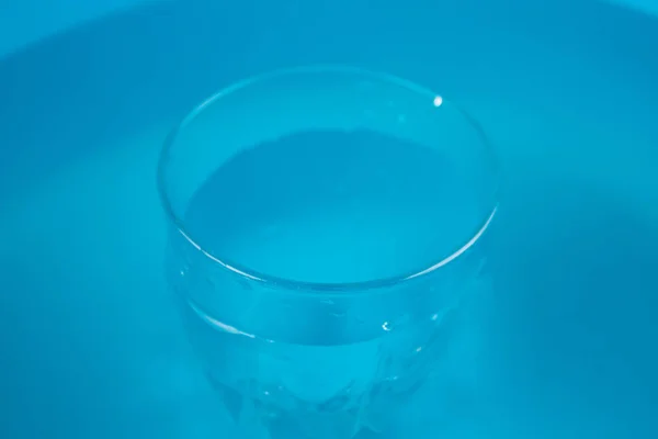 Bicchiere d'acqua su sfondo blu — Foto Stock