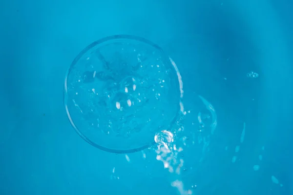 Vaso de agua sobre fondo azul —  Fotos de Stock