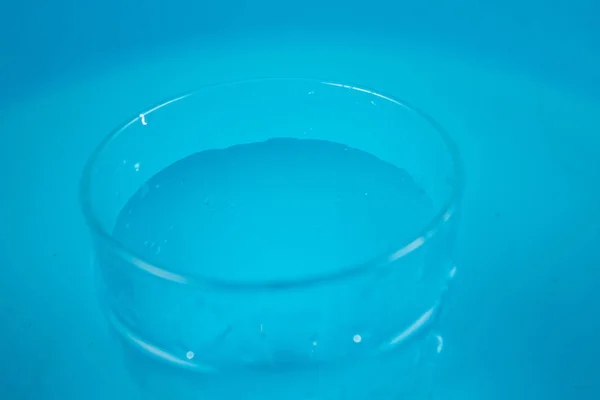 Стакан воды на синем фоне — стоковое фото