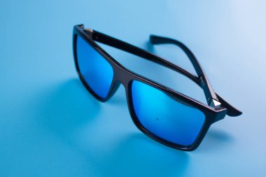 Mavi arka plan üzerinde güneş gözlüğü