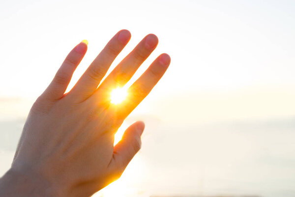 Изображение концепции летнего времени. Солнце светит сквозь пальцы, как бриллиант.
