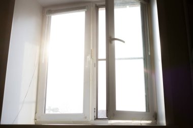 Güneş ışığı beyaz pencereden geçer. Ev