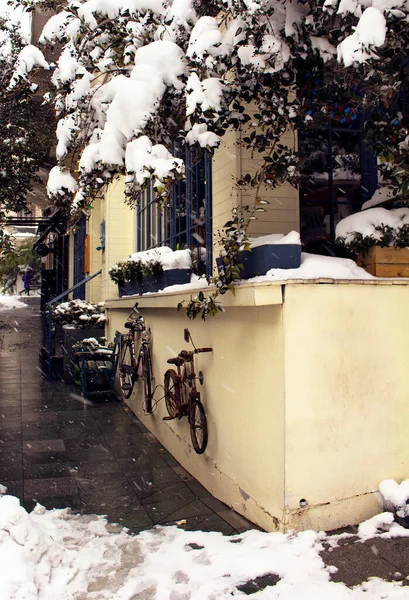 イスタンブールの高級地区 ニサンタシ の1つでカフェの景色 雪が激しく降る 二台の自転車がその場所の壁に掛けられている — ストック写真