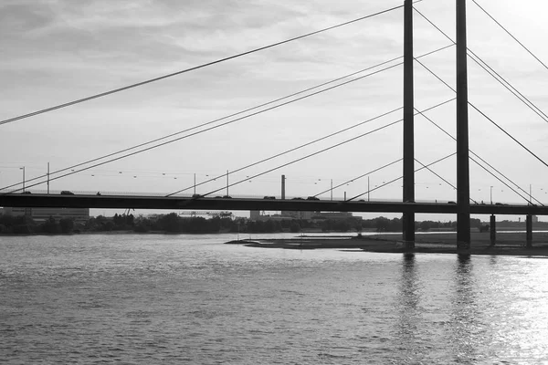 デュッセルドルフのバックライトを持つライン川とラインネブルック橋の黒と白の写真 — ストック写真