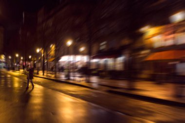 Paris 'te gece sokakta yürüyen bir kadının bulanık görüntüsü..