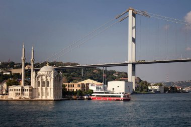 İstanbul 'un İstanbul' un eski ve tarihi Ortakoy Camii, tur teknesi, köprüsü ve Avrupa yakasının manzarası.