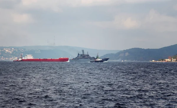 Dry cargo vessel and war ship crossing Bosphorus strait in Tarabya area of Istanbul.