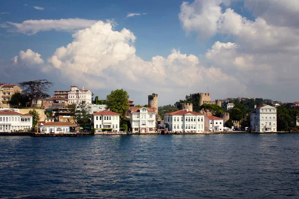 İstanbul 'un Asya yakasında tarihi, eski Türk / Osmanlı evleri ve Boğaz' ın bir kalesi manzarası. Güneşli / bulutlu bir yaz günü..