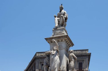 Bir güvercin İtalyan opera bestecisi Vincenzo Bellini 'nin Catania şehrindeki açık mavi gökyüzü heykelinin üzerinde oturuyor..