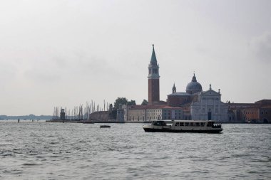 San Giorgio Maggiore Kilisesi, kanal ve sabah erken saatlerde Venedik / İtalya 'dan geçen bir tekne manzarası.