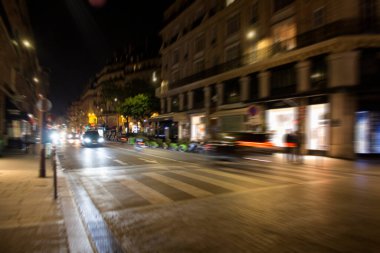 Paris 'te gece trafikteki arabaların bulanık görüntüsü.