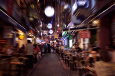 İstanbul 'da Taksim / Beyoğlu bölgesinde gece sokakta yürüyen insanların bulanık görüntüsü. Konum yoğun bir gece hayatı, alışveriş ve yemek bölgesi..