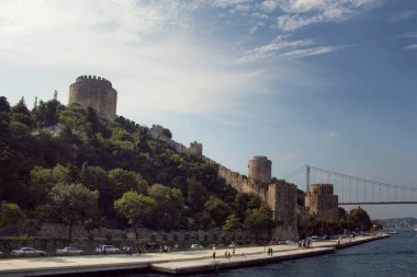 İstanbul 'da Boshorus, FSM köprüsü ve Rumelihisari veya Bogazkesen Kalesi' nden (ortaçağ kalesi) geçen insanların görüntüsü. Güneşli bir yaz günü..