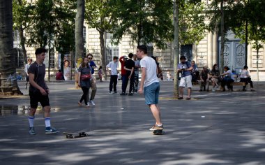 Gençler Paris 'teki Cumhuriyet Meydanı' nda (Place de la Republique) kayıyorlar. Görüntü şehrin gençlik kültürünü gösteriyor..