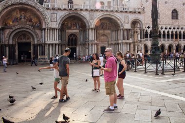 Venedik 'teki Aziz Mark Bazilikası (Basilica di San Marco) önünde bir grup turist. Mağaranın içi yaldızlı, sayısız mozaiği ve müzesi olan bir Iconic katedrali..