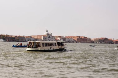Venedik / İtalya 'nın arka planında tarihi binalar olan kanal üzerindeki su otobüsü görüntüsü. Adriyatik Denizi 'ndeki bir gölde 100' den fazla küçük ada üzerine inşa edilmiştir..